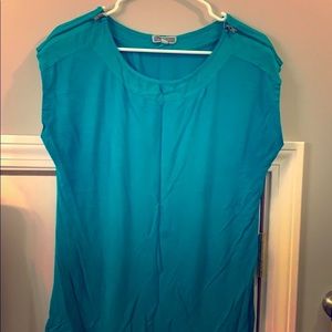 Teal short sleeve top with gold zippers on the shoulders